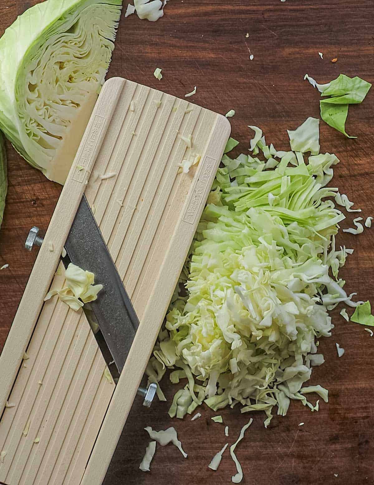 Shredding cabbage using a mandoline cabbage slicer. 