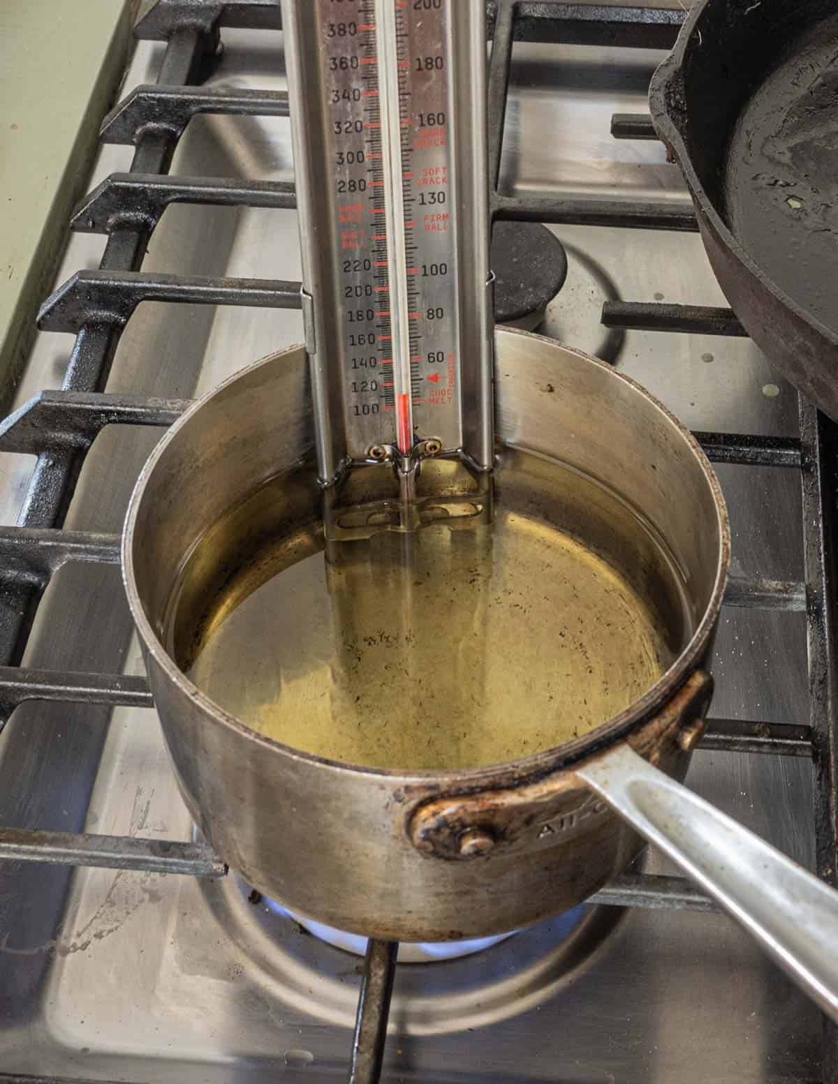 Heating oil for frying with a candy thermometer. 