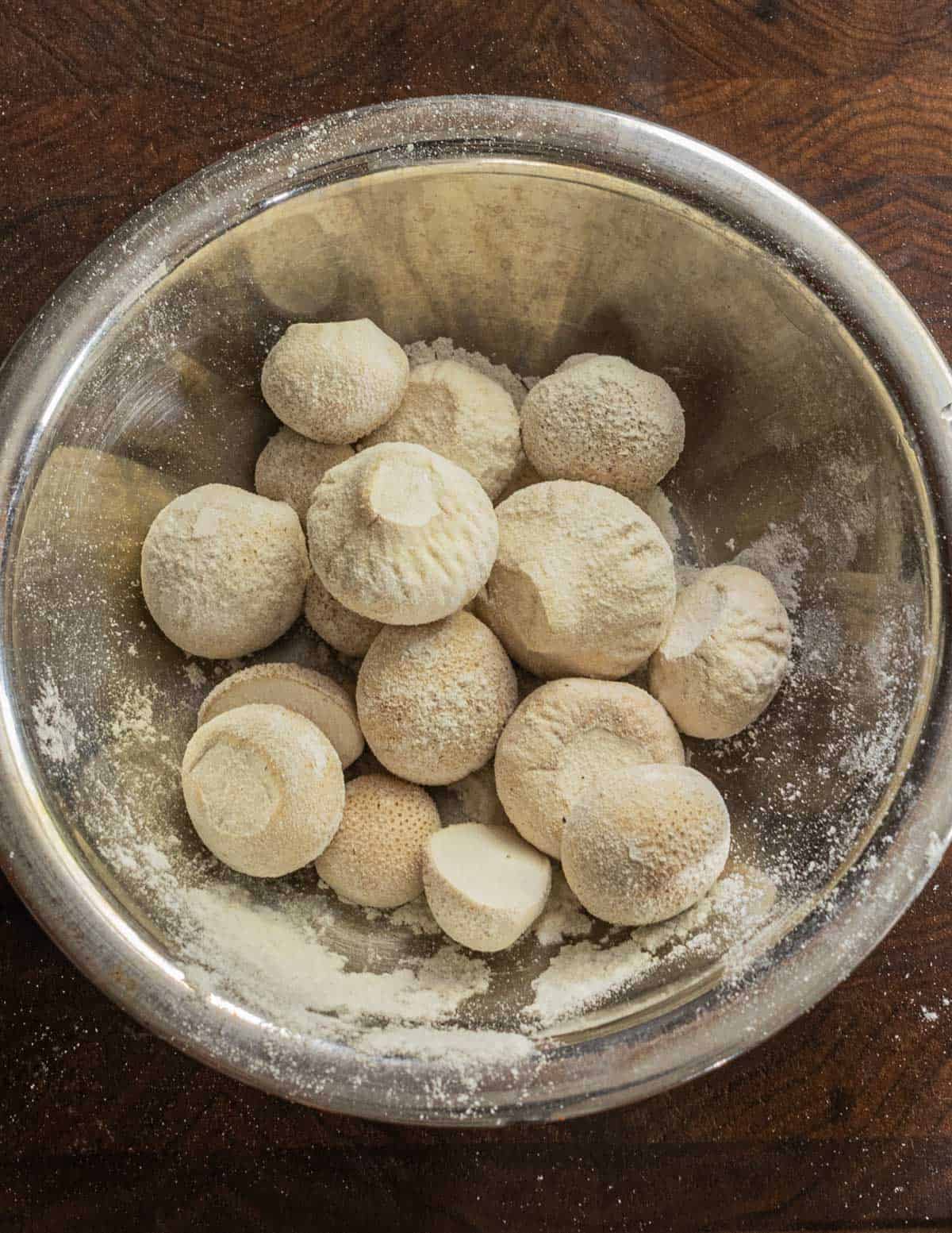 Tossing gem puffball mushrooms lightly in flour before frying. Tossing mushrooms lightly in flour before frying.