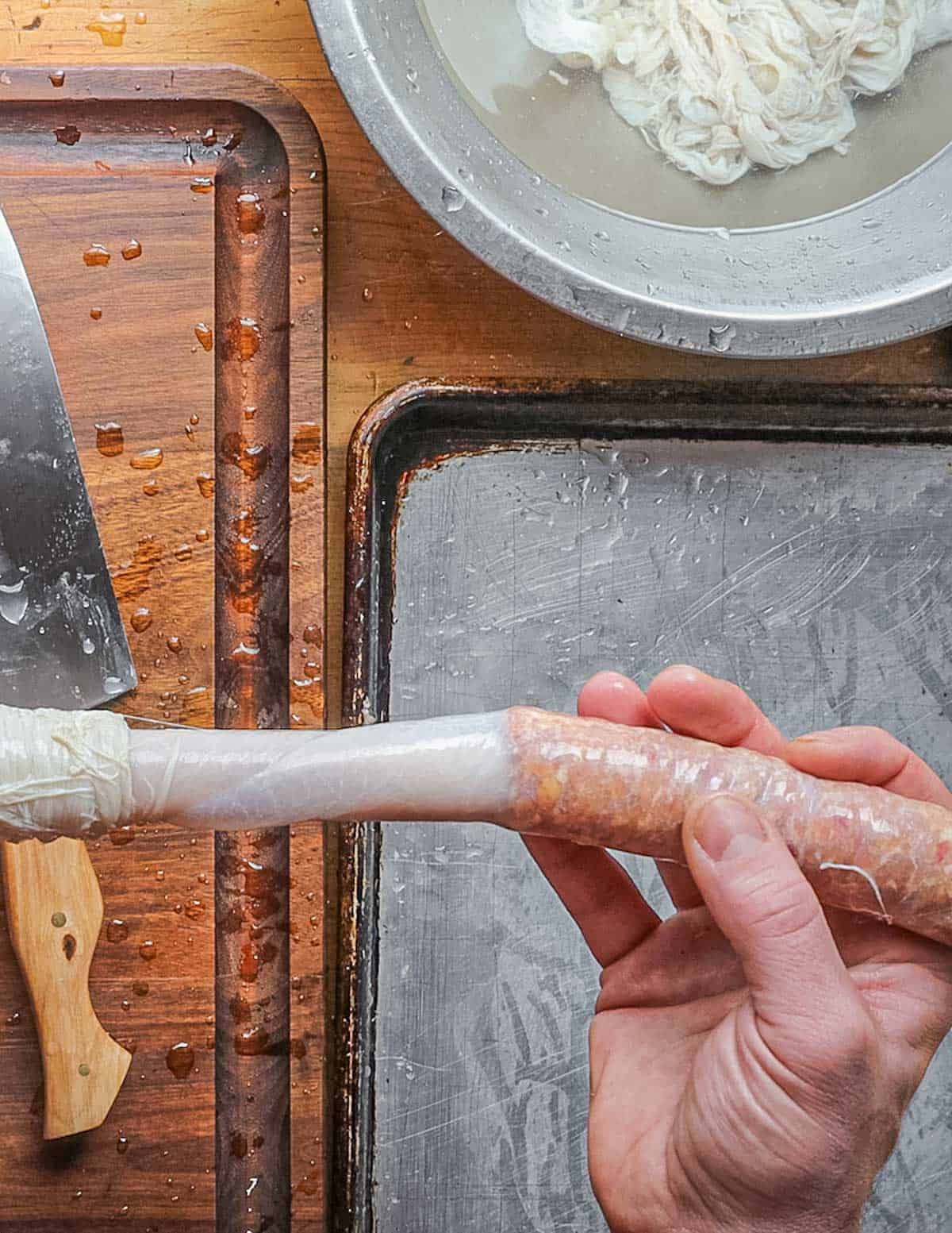 Packing chicken sausage into hog casings using a sausage stuffer. 