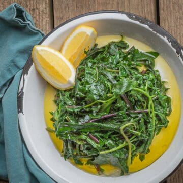 A dish of cooked horta greens with extra virgin olive oil and lemon juice.