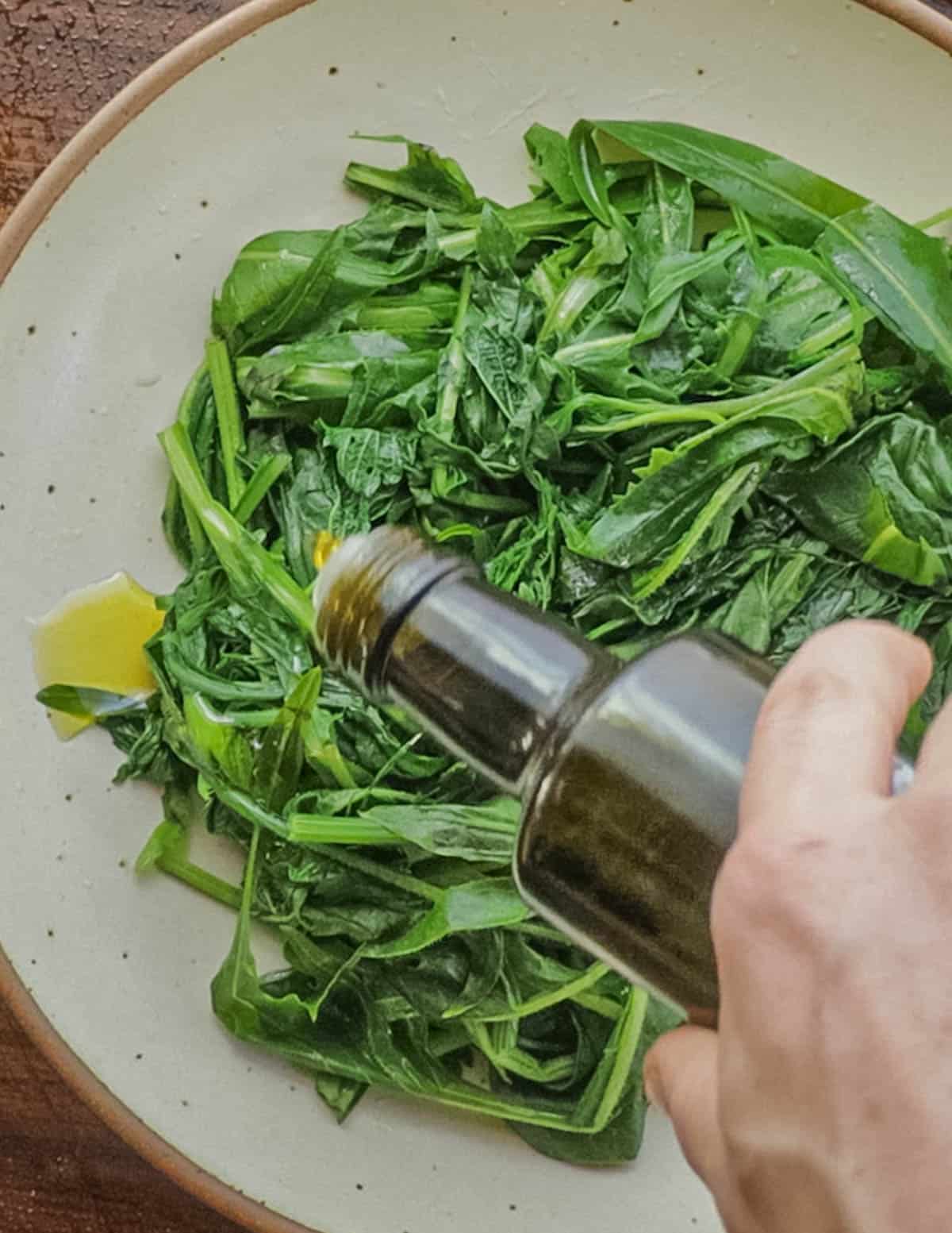 Drizzle extra virgin olive oil over the greens. 