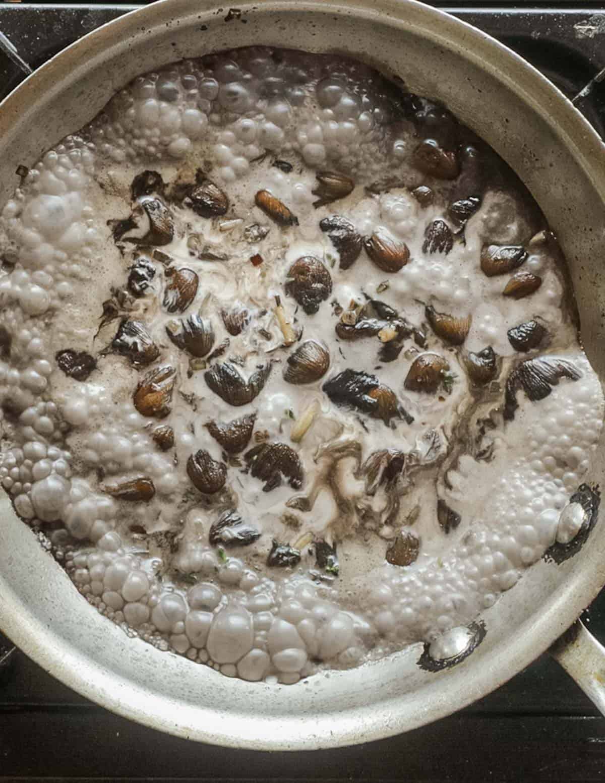 Simmering a mica cap mushroom sauce until thickened. 