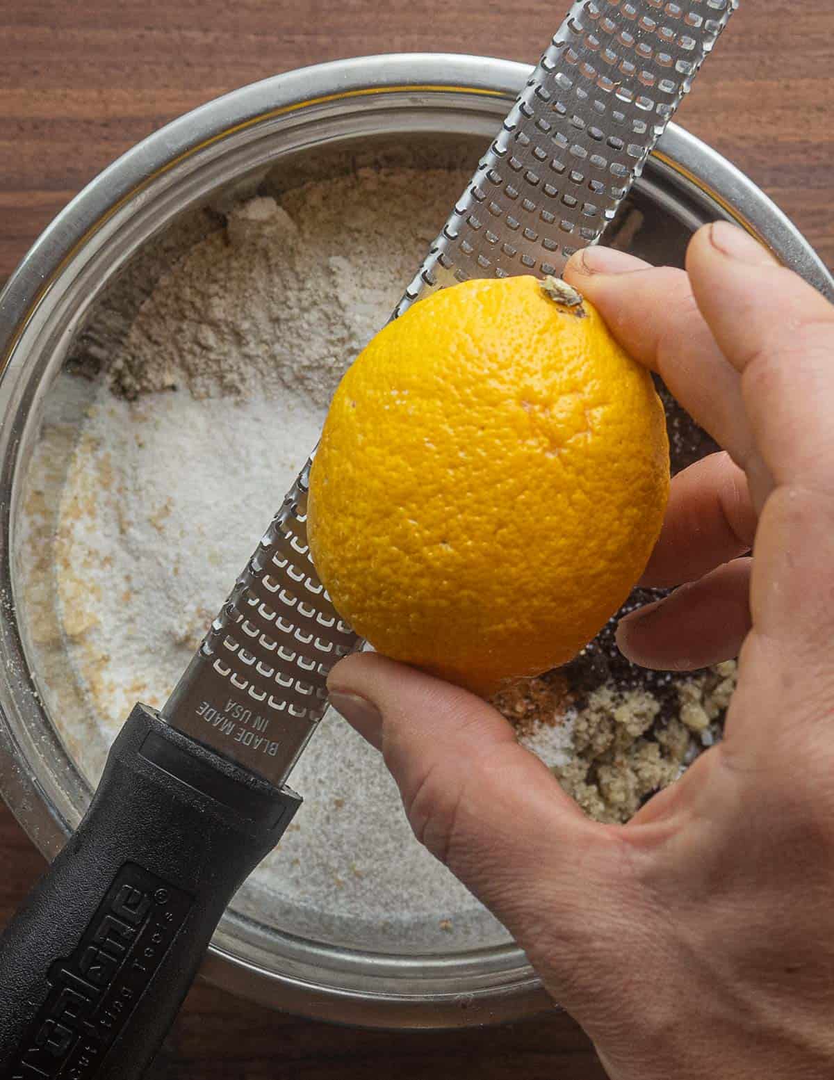 Adding grated lemon zest to a batch of black walnut cookies. 