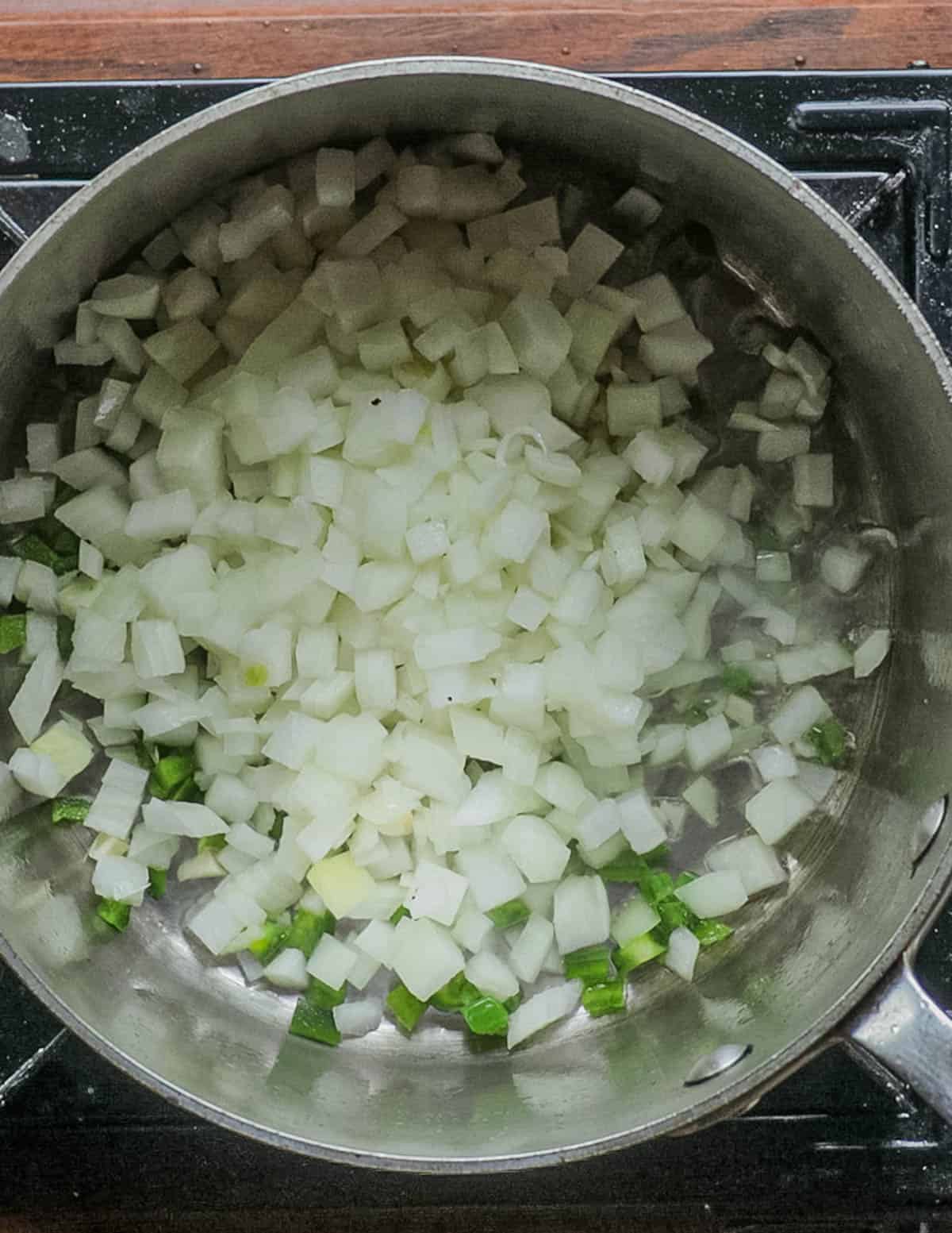 Cooking garlic, onion and jalapeno in a soup pot. 