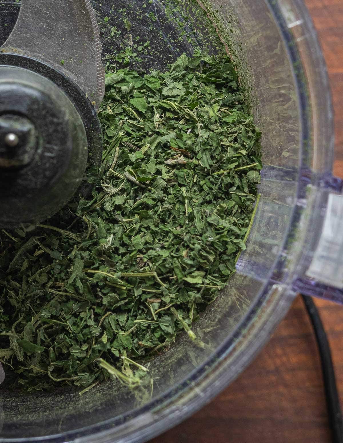 Processing dried nettle leaves in a food processor for tea. 