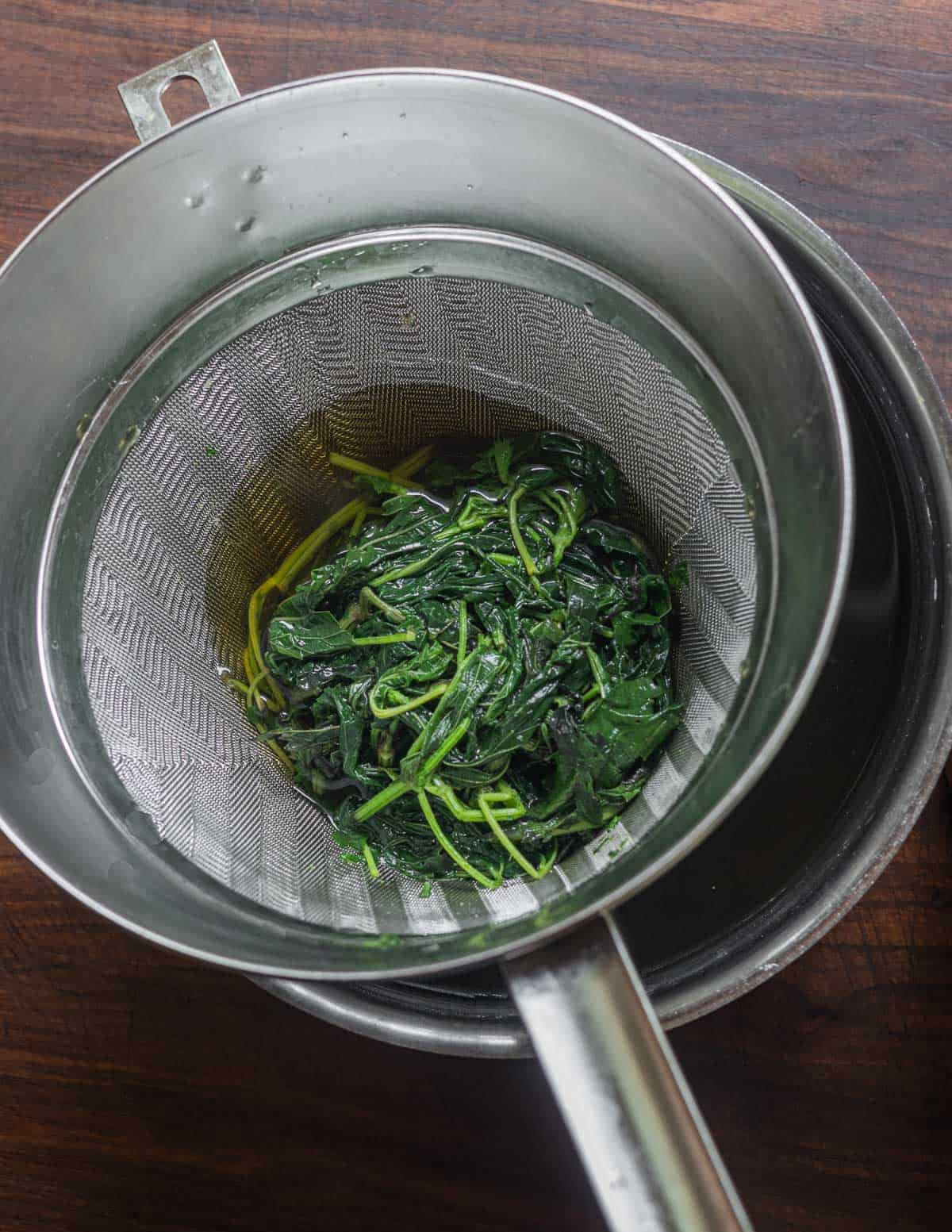 Straining finished nettle tea with mint. 