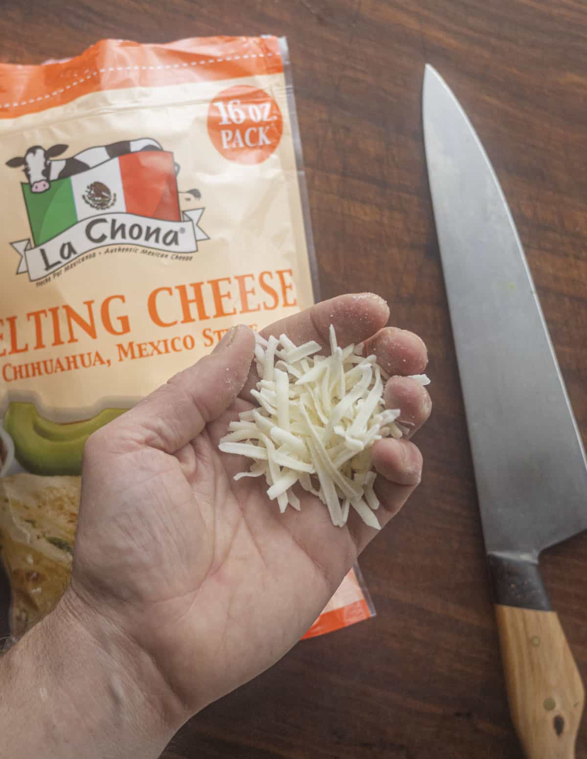 A hand holding queso chihuahua cheese for making quesadillas. 