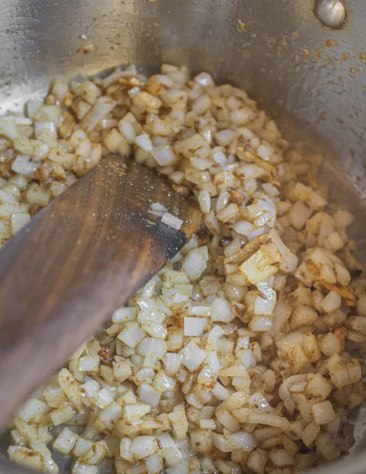 Cooking onions and garlic with ground cumin. 