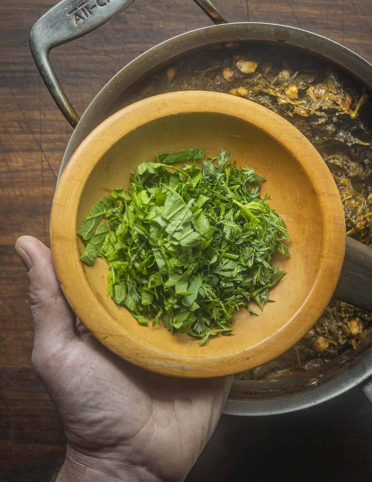 Finishing plant based tacos with fresh cilantro and epazote. 