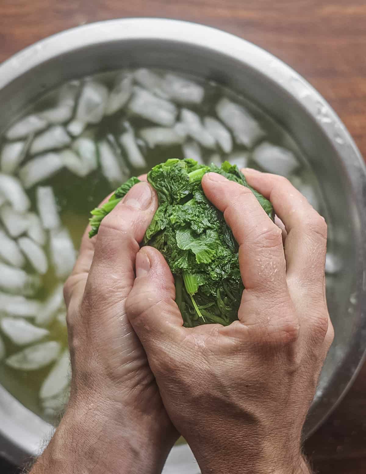 Squeezing the water from cooked greens. 