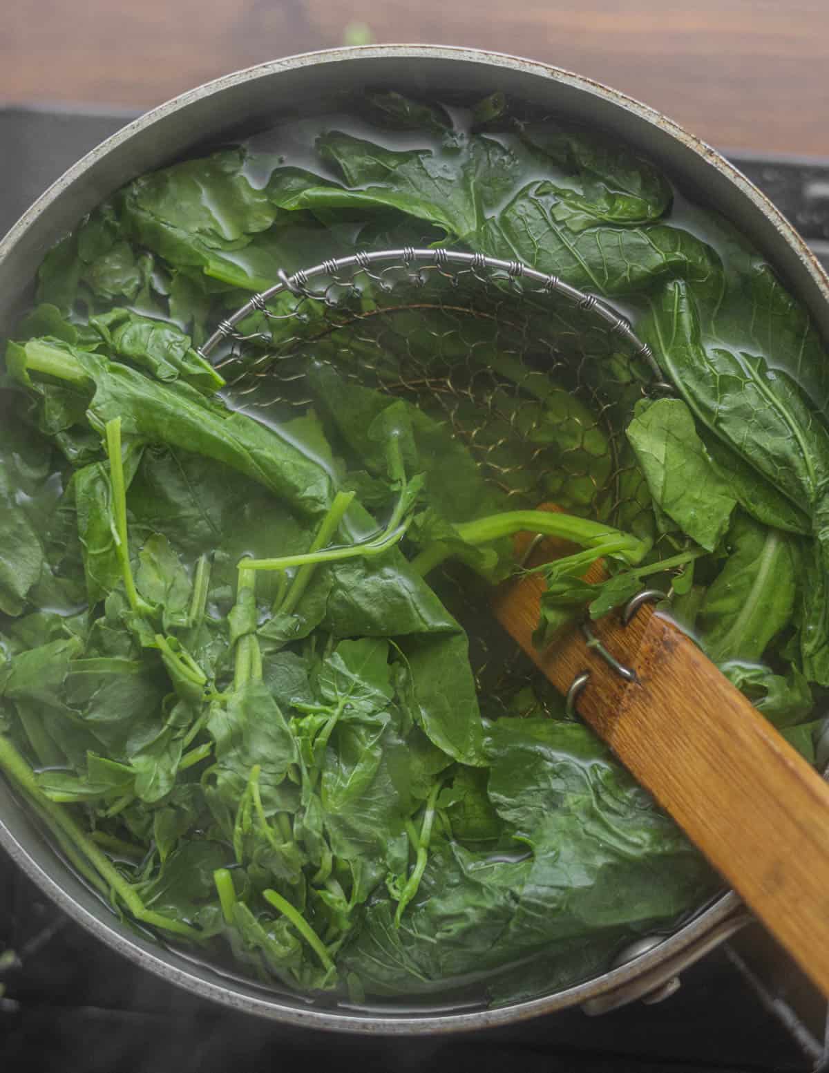 Blanching leafy greens in boiling water. 