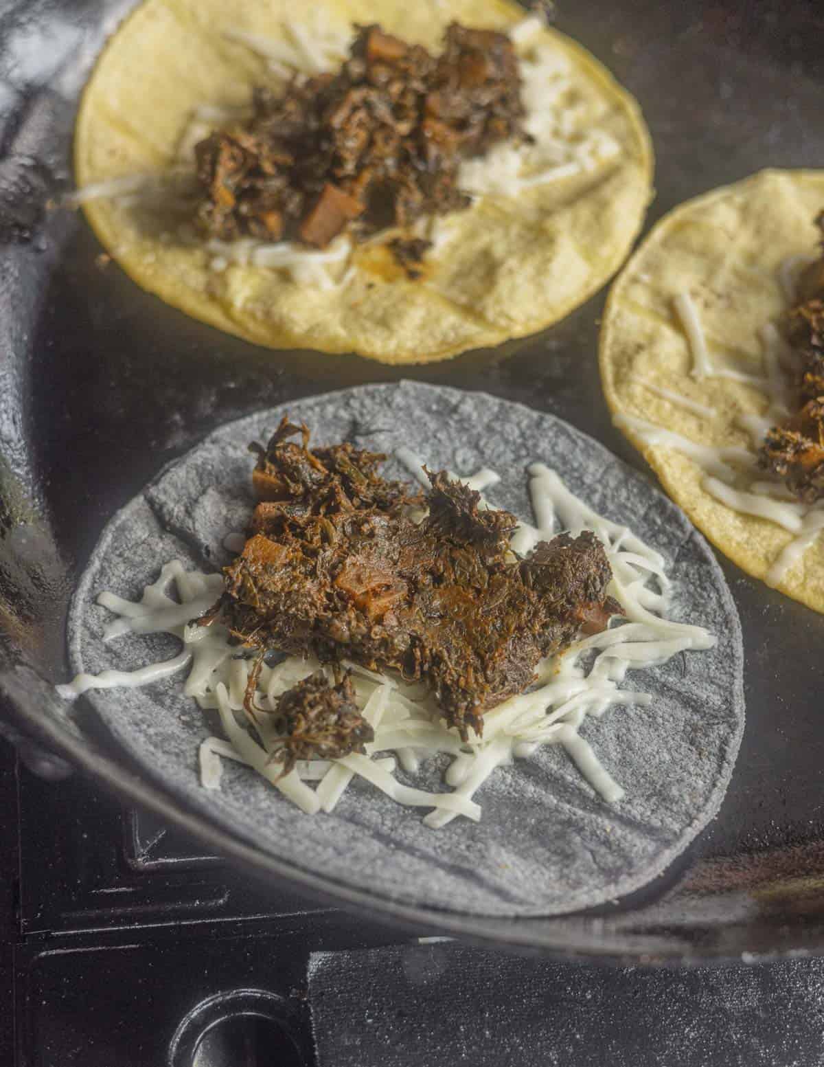 Making plant based quesadillas with corn tortillas in a cast iron pan. 