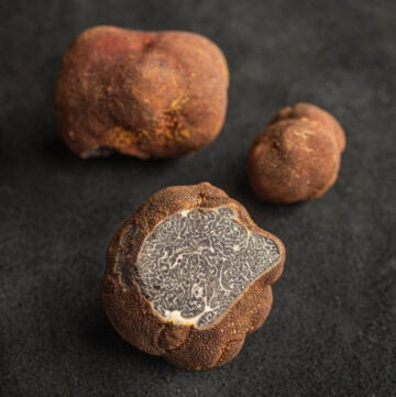 Three Appalachian truffles (Tuber canaliculatum) with one cut showing the inner brown