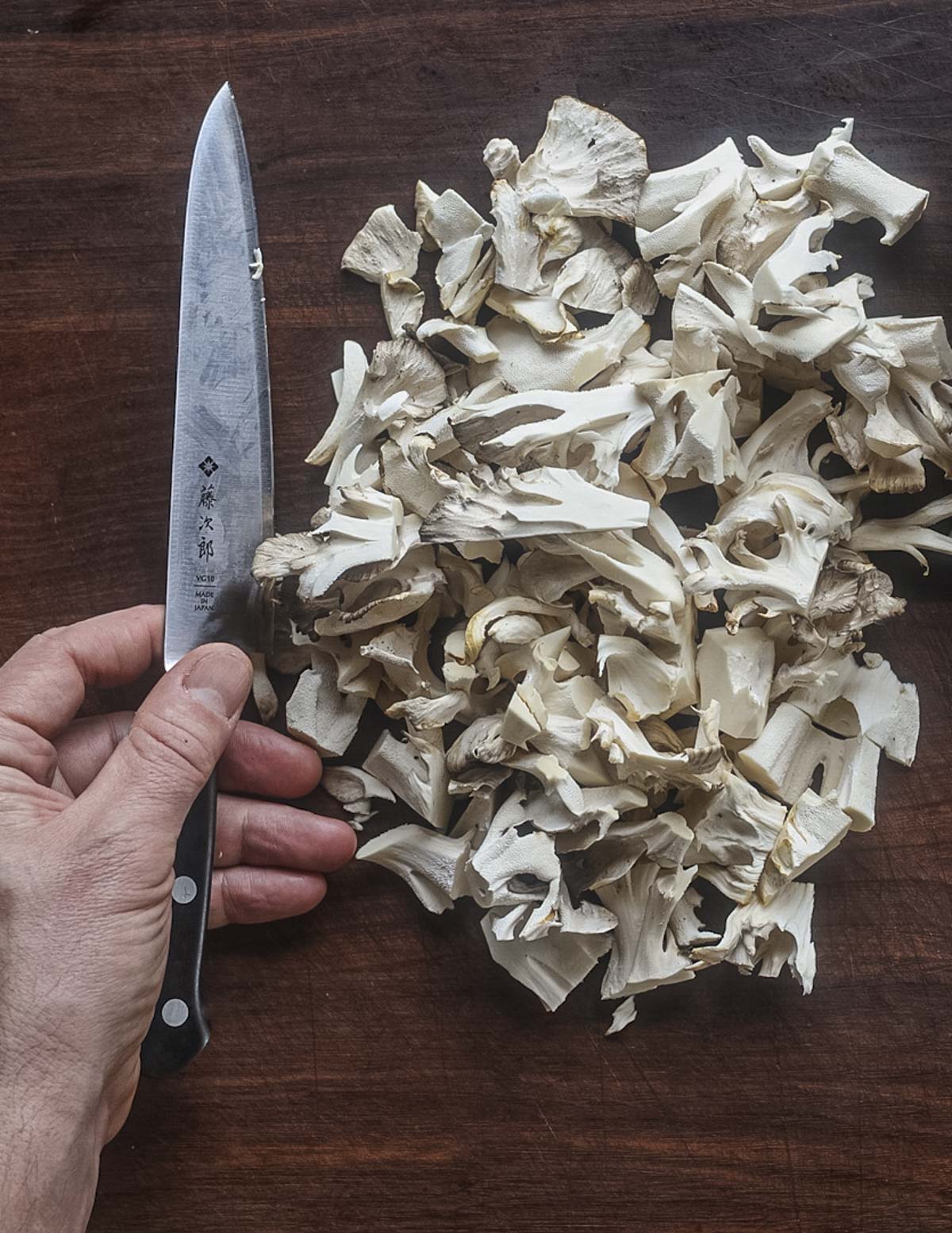 Cutting mushrooms into bite sized pieces. 