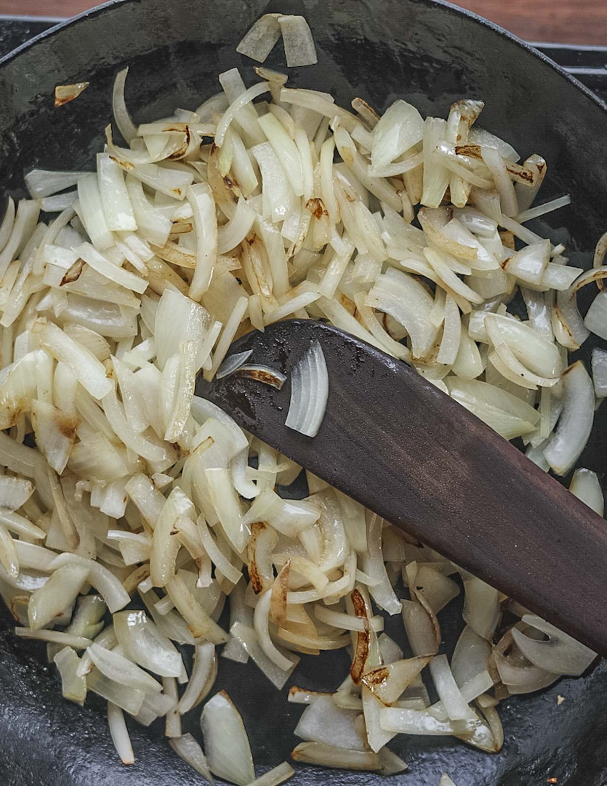 Cooking onions in a pan until golden brown. 