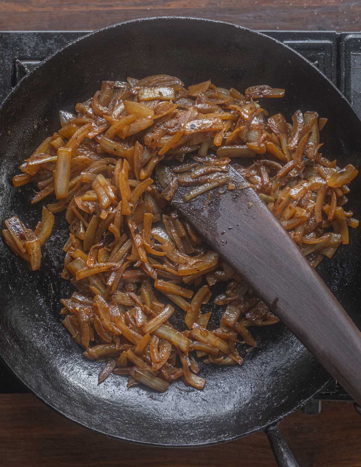 A pan of finished dark brown caramelized onions. 