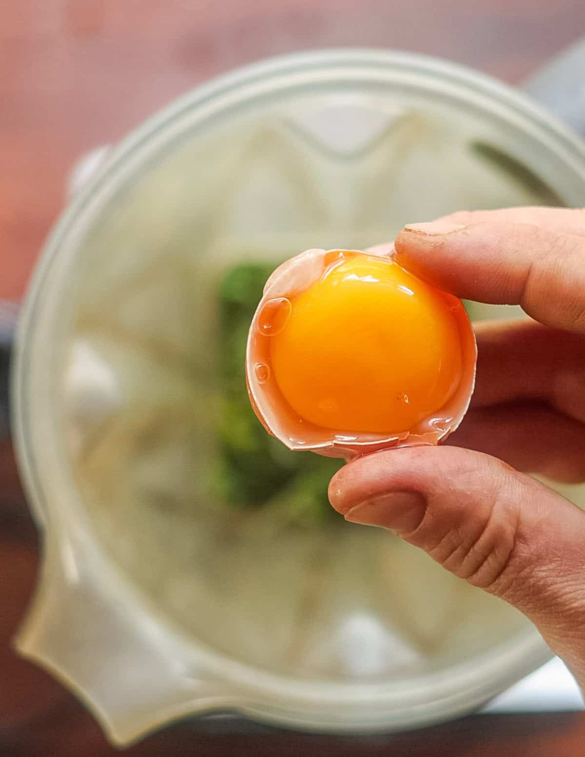 Adding a whole egg yolk to a blender. 