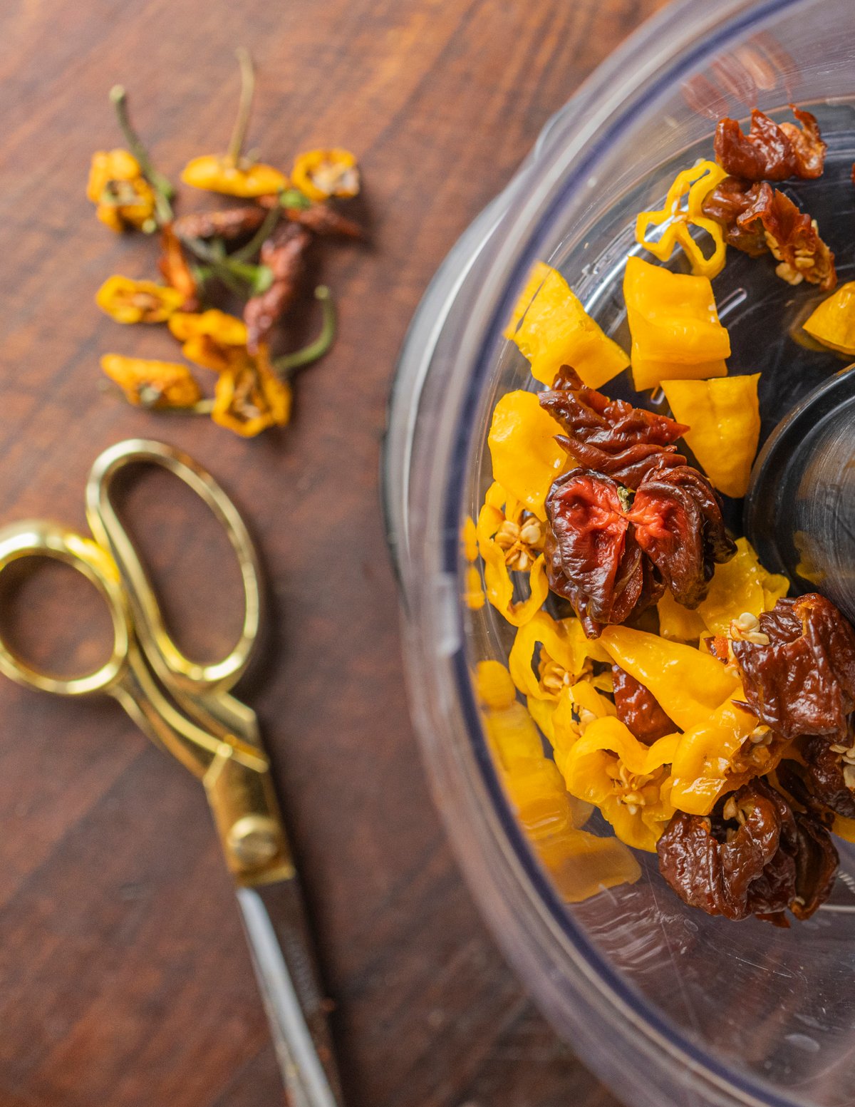 Cutting super hot Carolina reaper and fatalii peppers with a scissors directly into a food processor. 