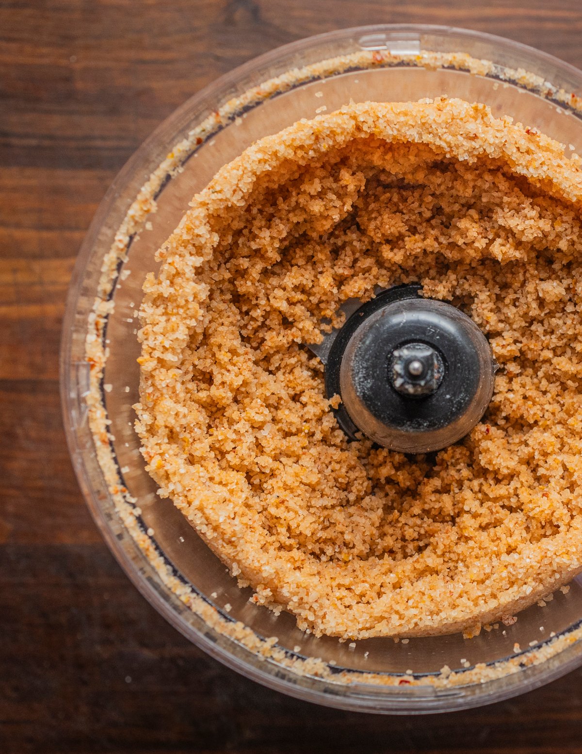 A food processor filled with salt blended with fresh hot peppers. 