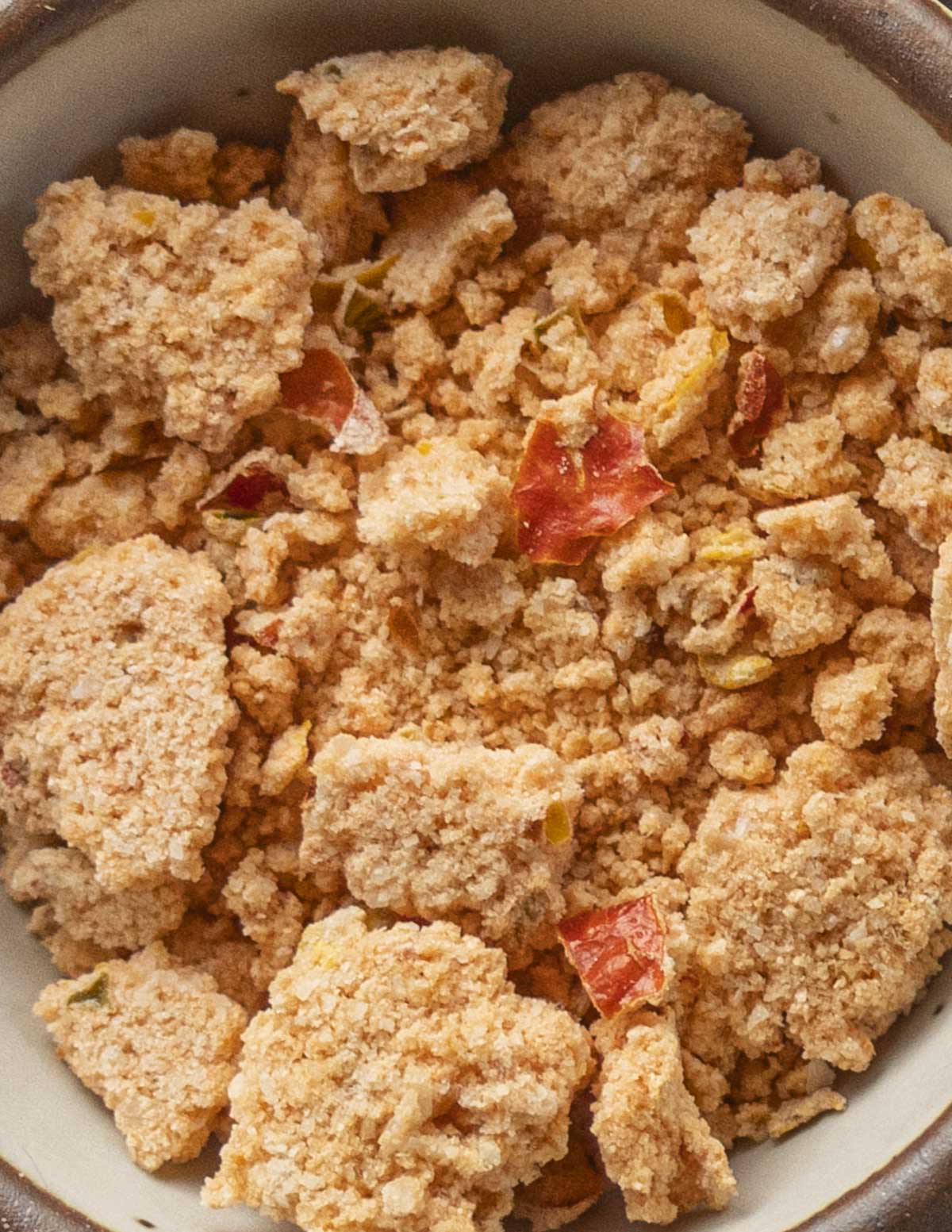 A small bowl showing clumps of hot pepper salt and large pieces of dried chili skin. 