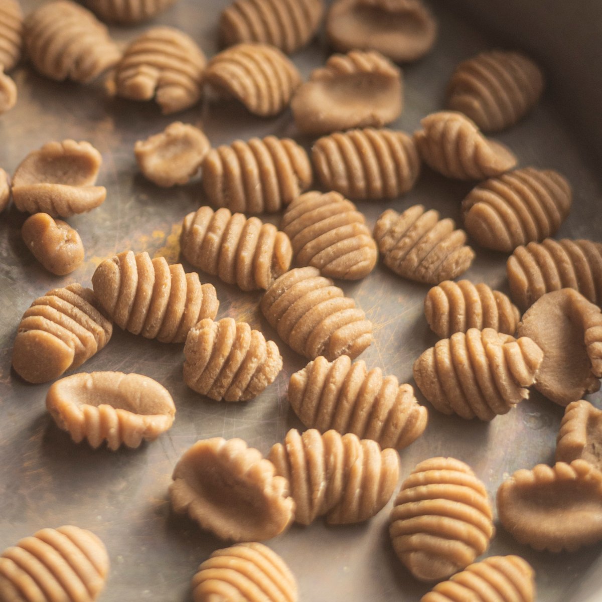 Finished, formed chestnut gnocchi on a pie plate. 