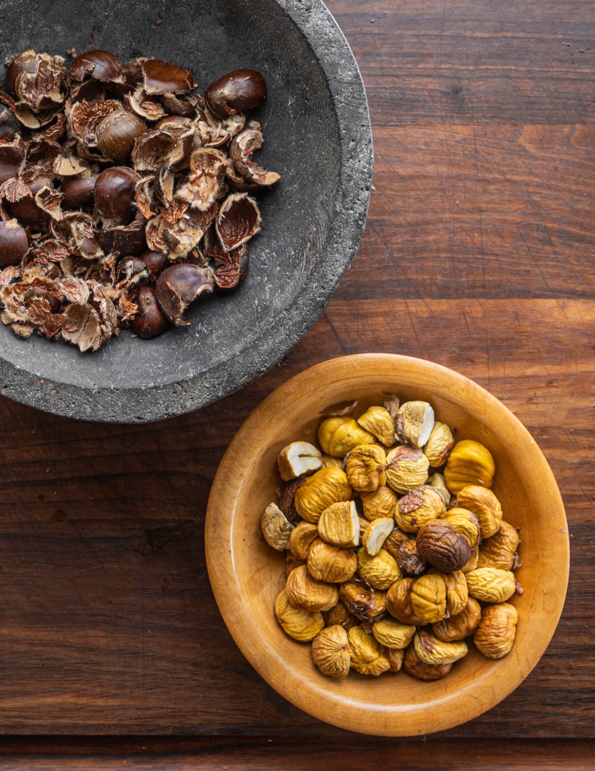 Cracking dried chestnuts using a mortar and pestle.