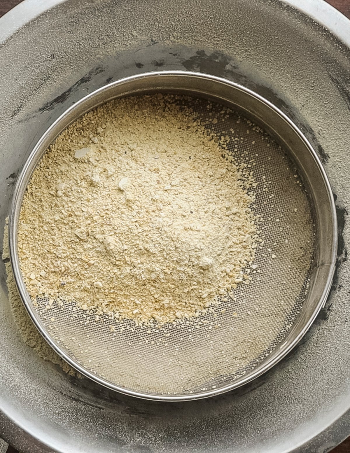 Sifting ground dried chestnut flour to remove particles. 