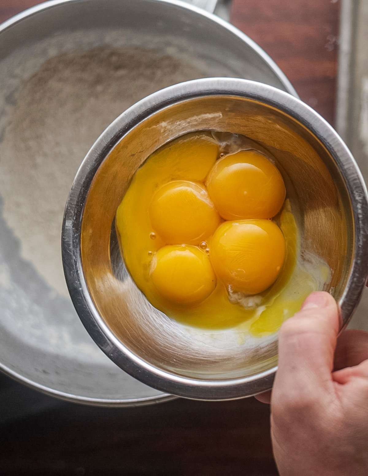 Adding whole eggs to a stand mixer with chestnut flour to make gnocchi dough. 