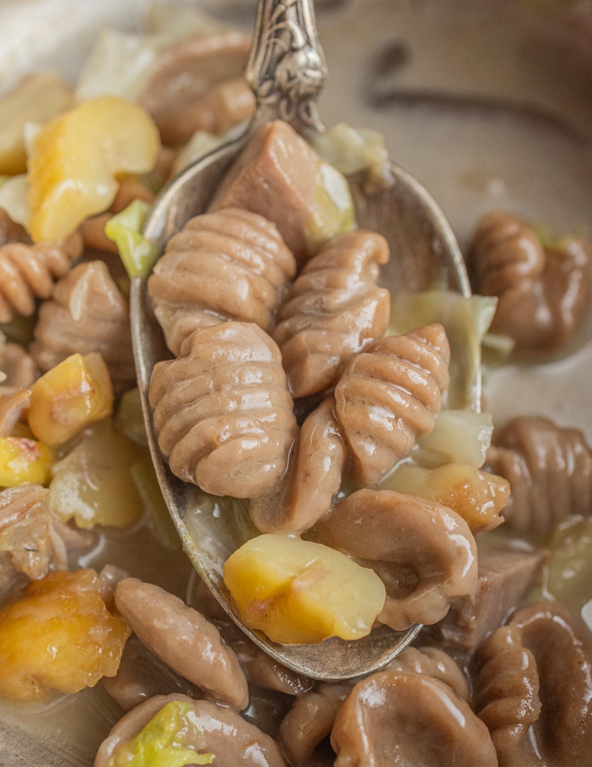 Chestnut gnocchi in a pan with goose confit, cabbage, and roasted chestnuts. 