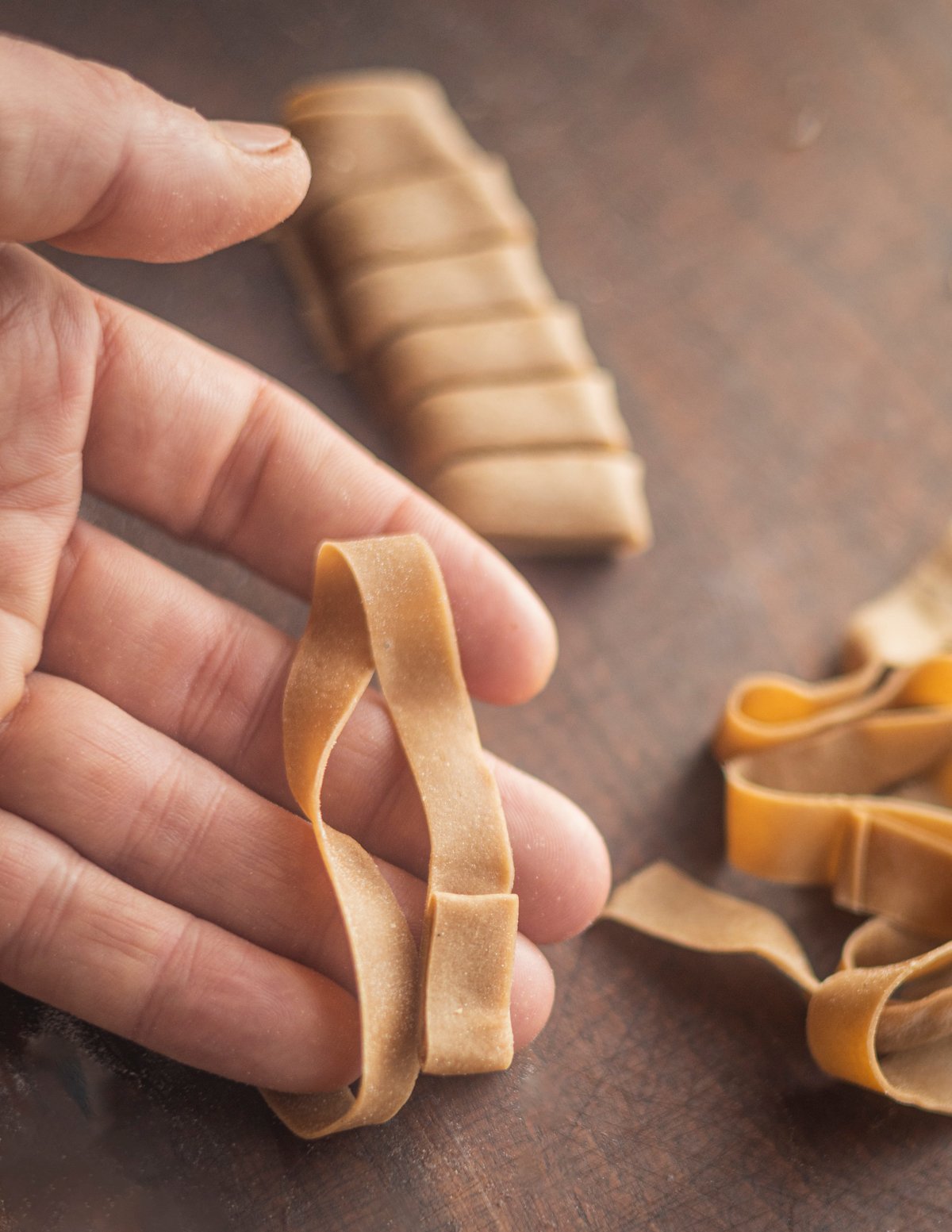 Unraveling rolled noodles of chestnut flour pasta dough. 