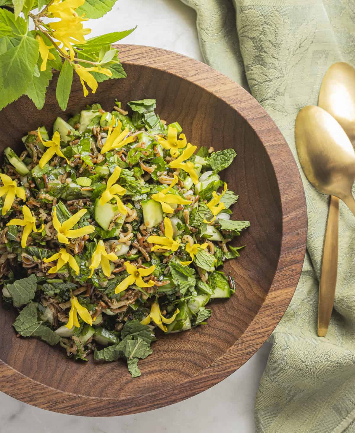 A bowl of ground elder tabouleh salad with wild rice and cucumbers. 