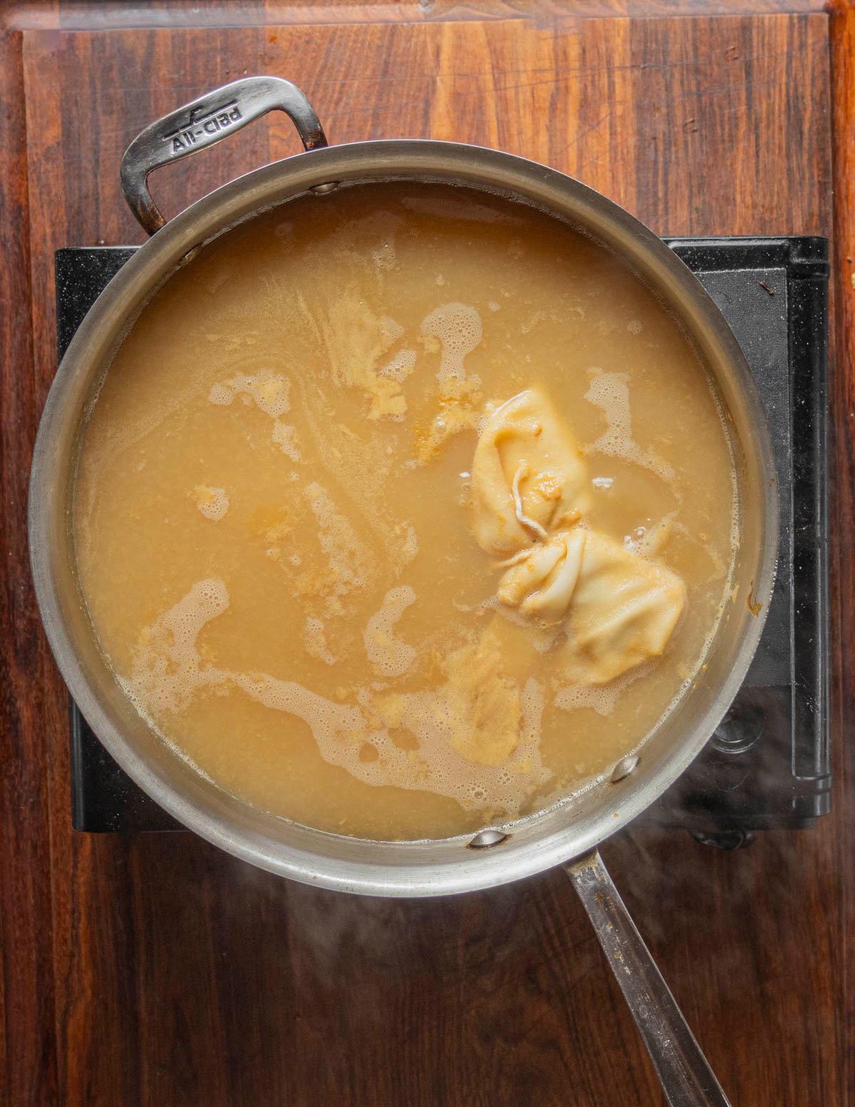 Boiling a pan of pear juice showing a reduction in volume. 