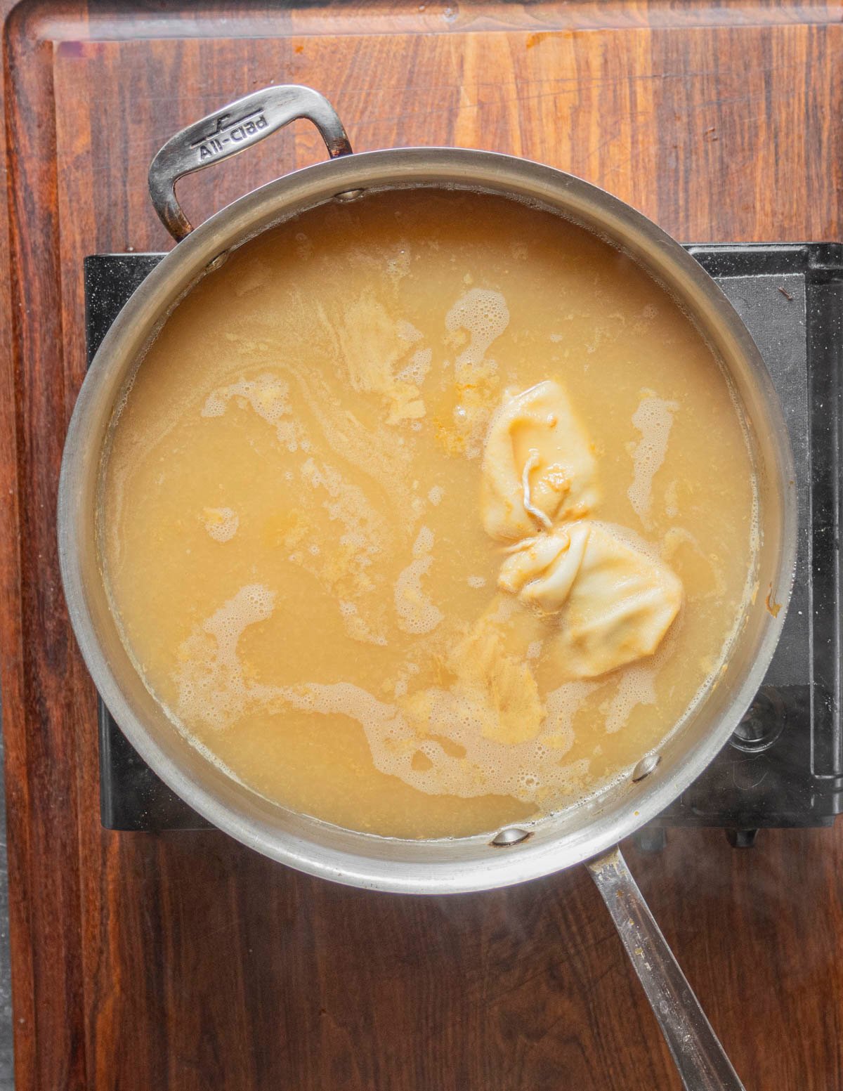 A pan of pear juice with a spice bouquet simmering. 