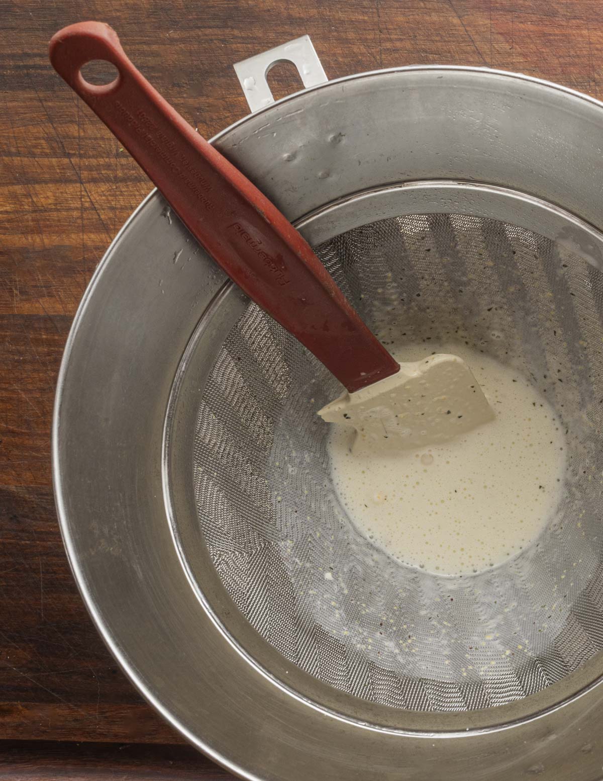 Straining an ice cream custard through a fine strainer. 