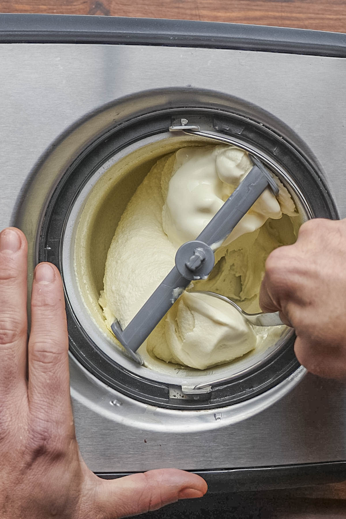 Removing finished ice cream from an ice cream maker.