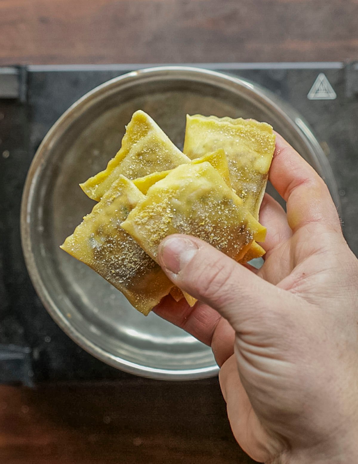 Adding ravioli to a pot of boiling salted water. 