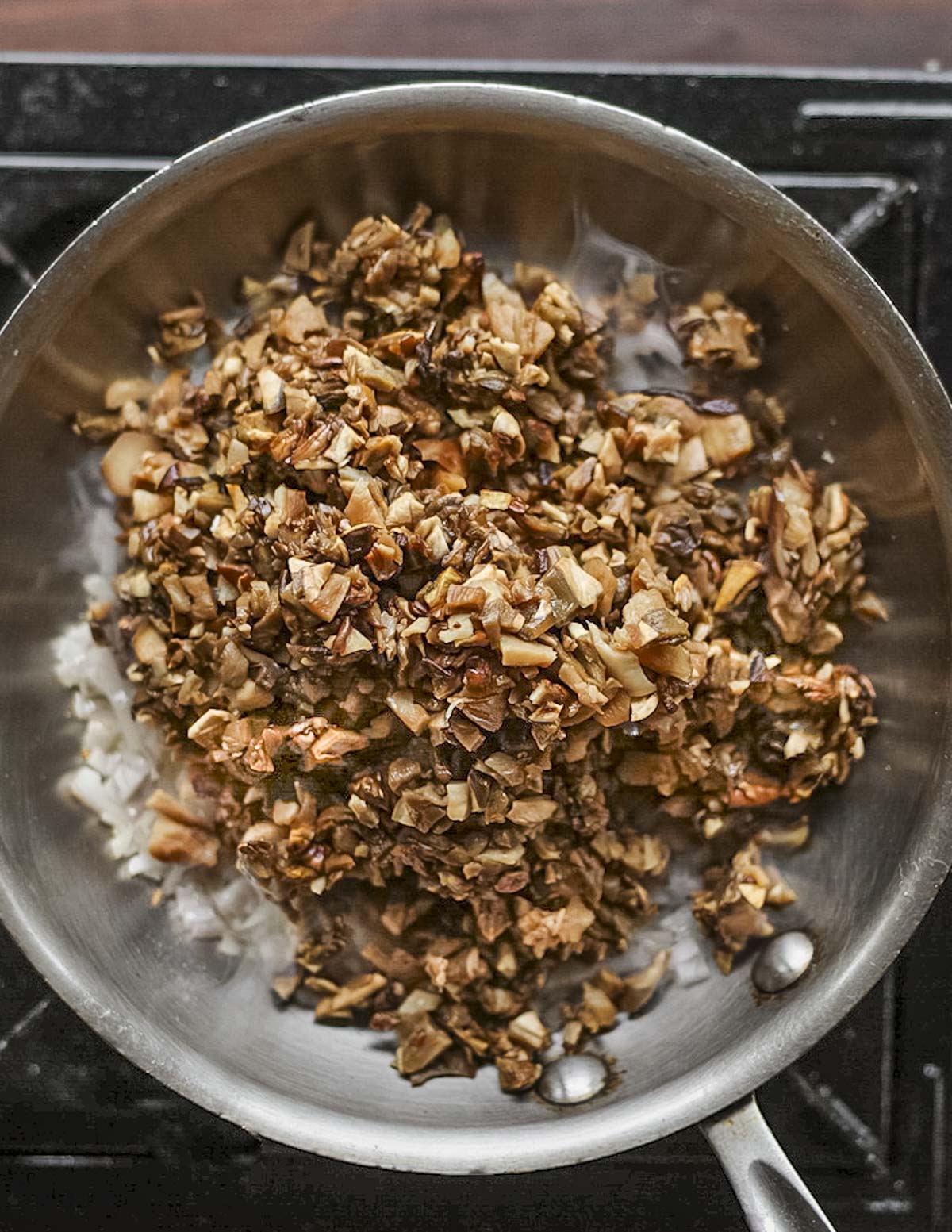 Cooking dried porcini mushrooms with shallots in a pan with oil. 