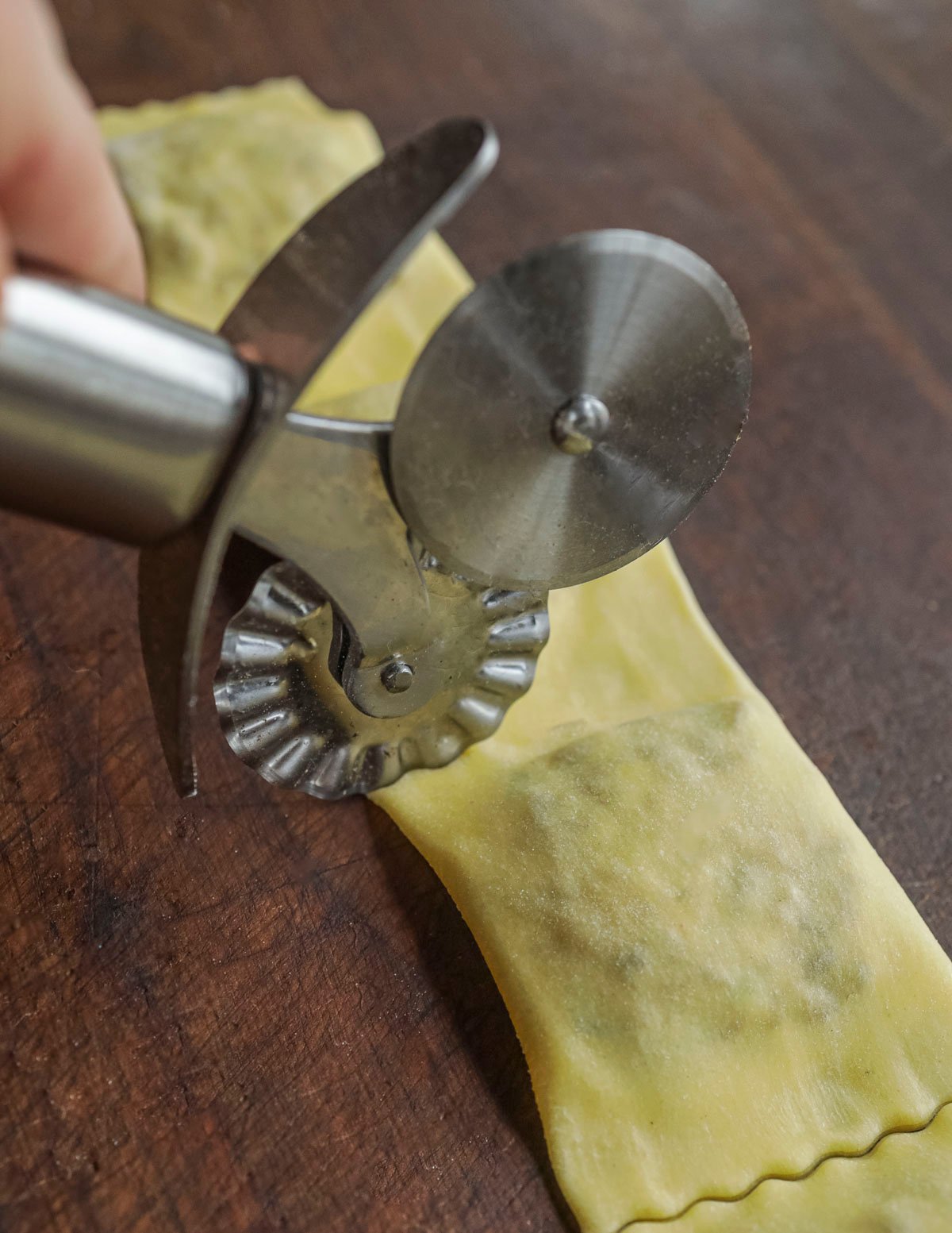 Cutting finished ravioli with a fluted pastry cutter. 