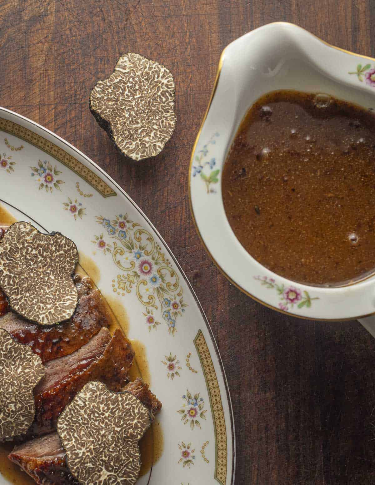 A sauce boat filled with black truffle goose gravy or sauce perigueux. 