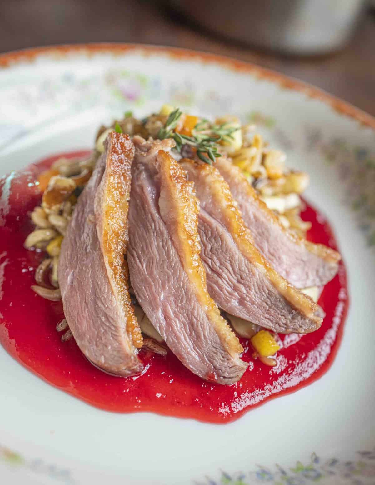 Pan roasted goose breast served with a highbush cranberry sauce, wild rice and butternuts. 