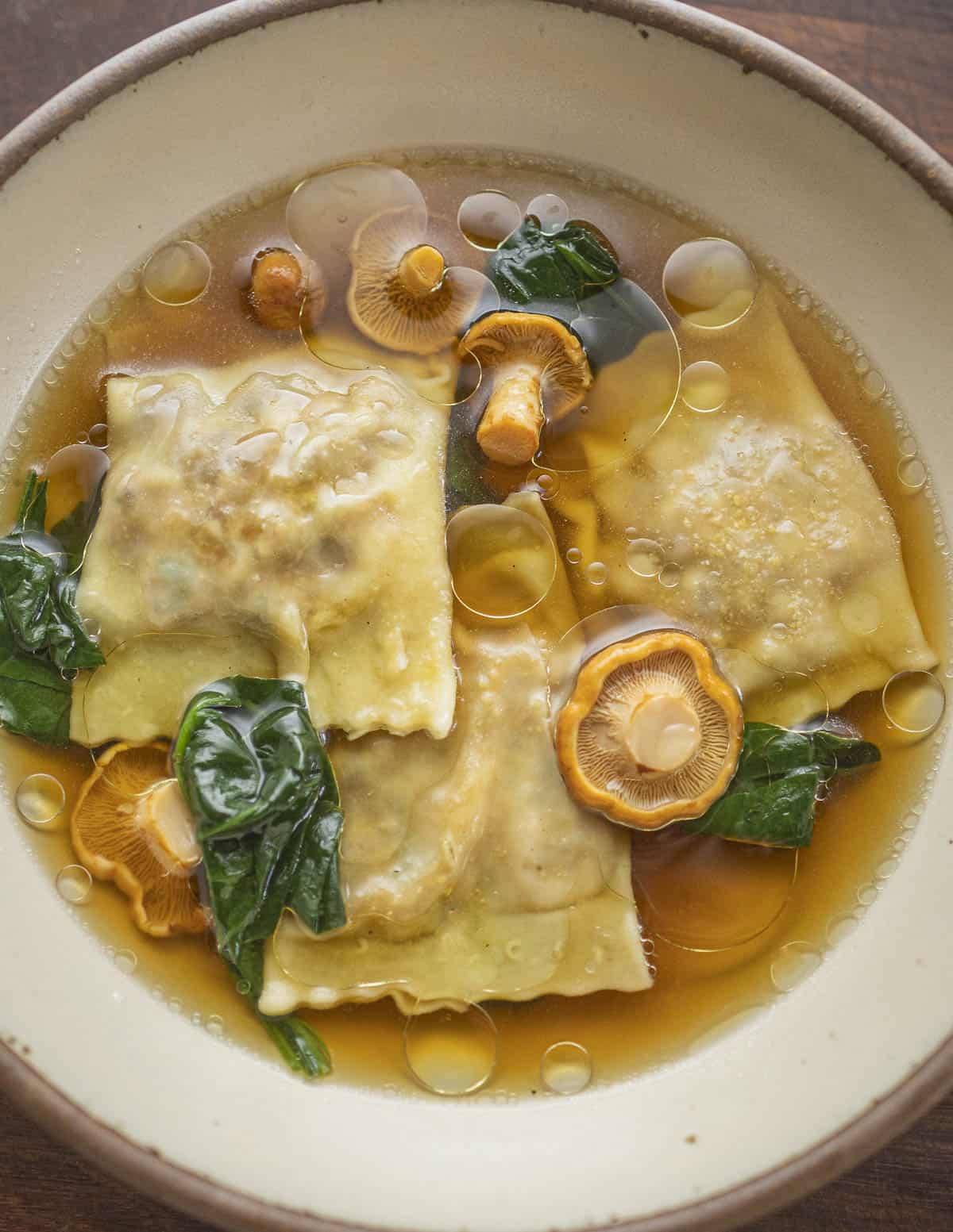 Mushroom ravioli en brodo garnished with truffle oil. 