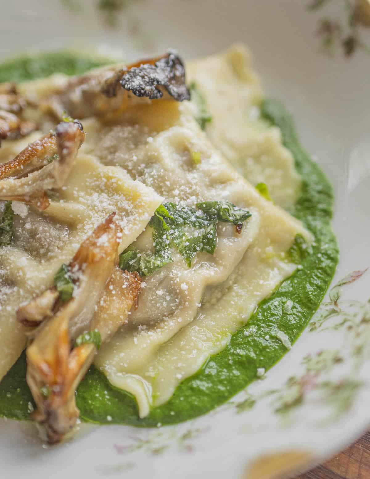 Mushroom ravioli on a bed of fresh spinach puree with sauteed mushrooms. 