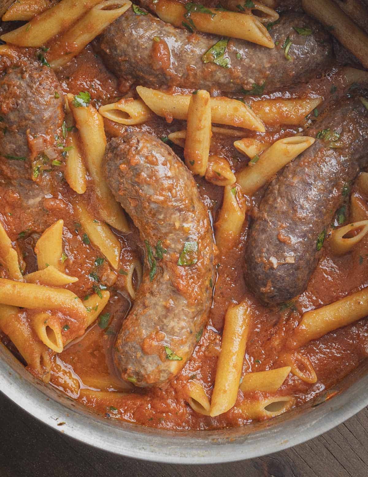 Baked italian sausages in tomato sauce with penne pasta. 