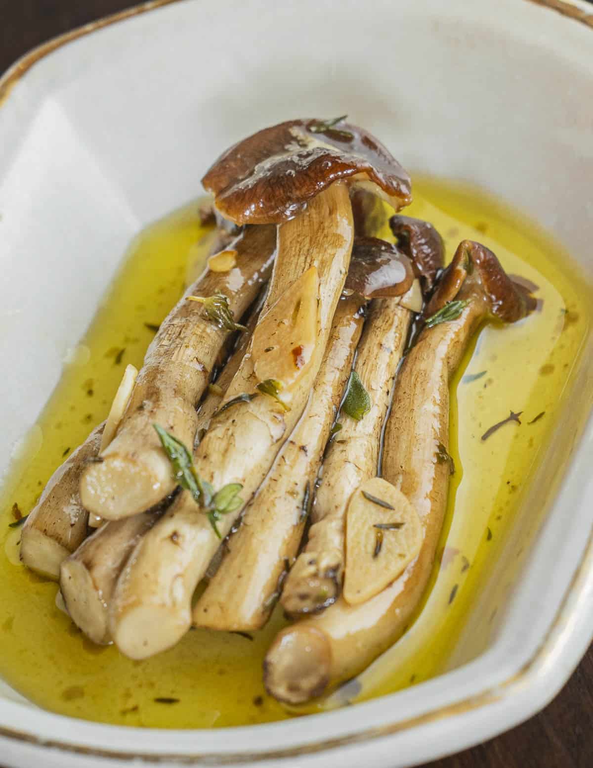 A plate of marinated pioppino mushrooms with olive oil and herbs. 