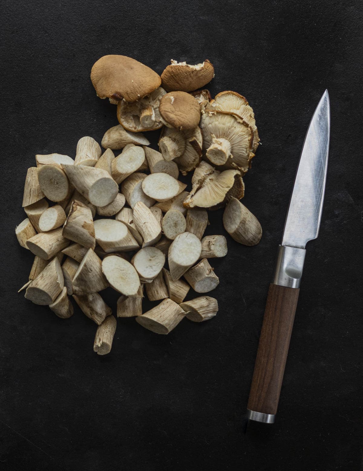 Cutting pioppino mushrooms into large pieces for cooking.