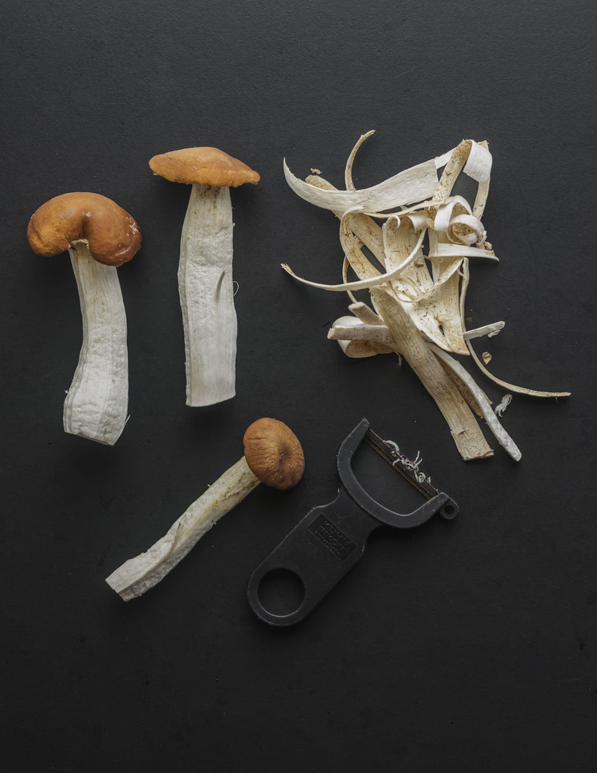 Peeling large pioppino mushrooms with a kuhn rikon peeler. 