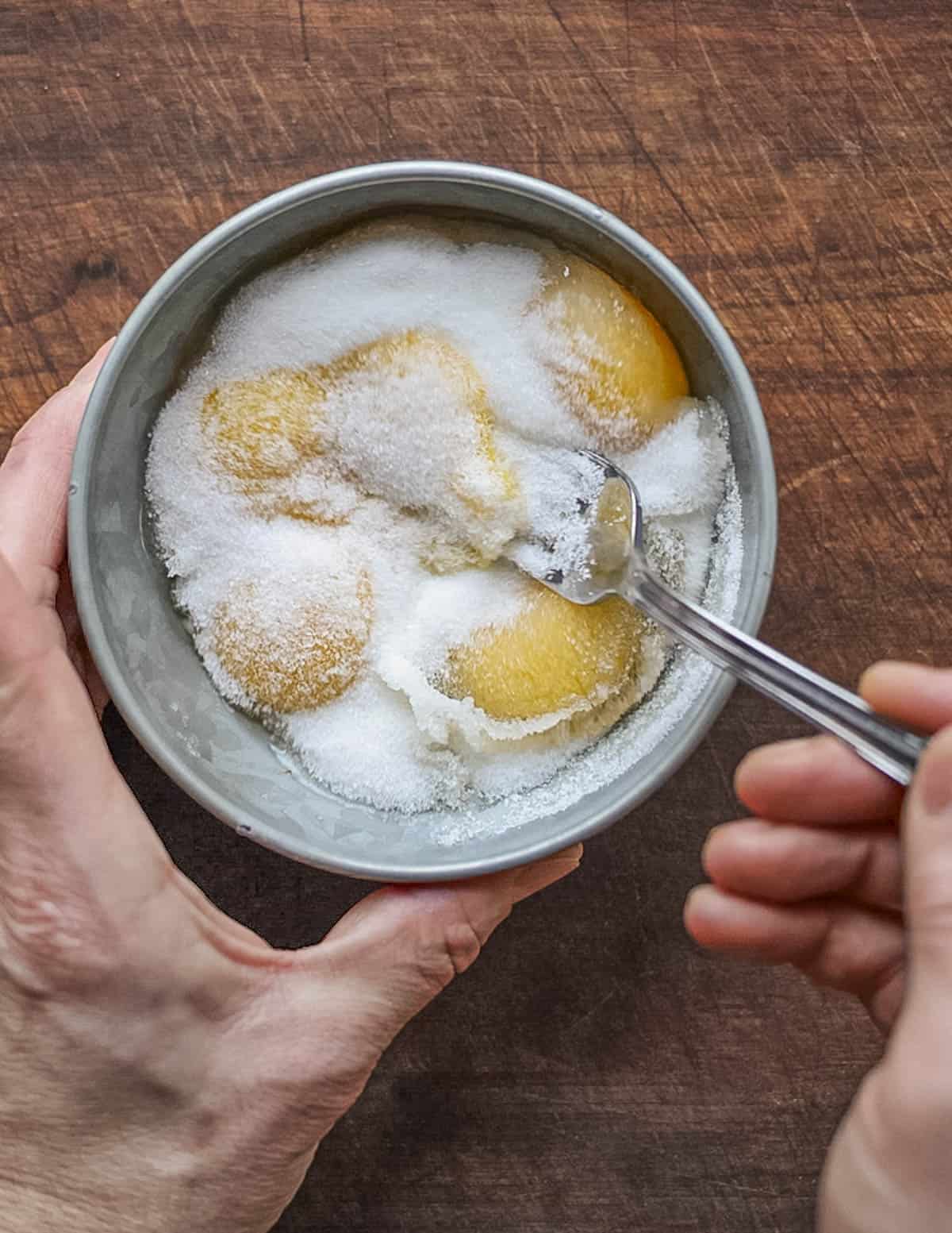 Beating eggs and sugar together in a bowl. 