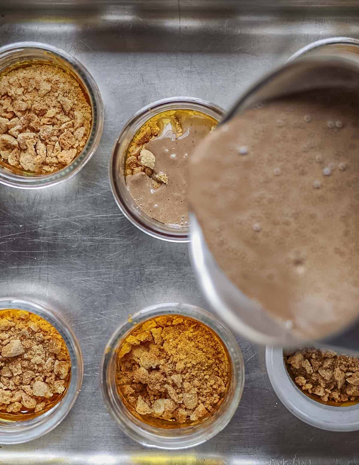 Pouring chocolate custard into ramekins. 