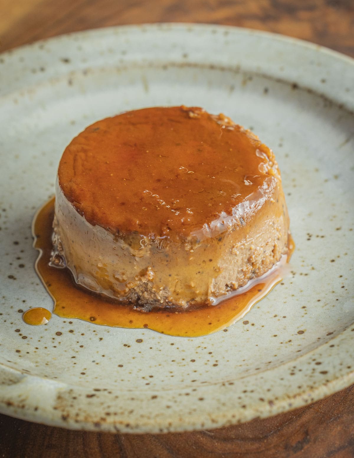 Unmolding a cooked custard on a dessert plate with caramel  sauce. 